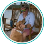 editor in chief of darling dog magazine sitting on alabama dock with his golden retriever