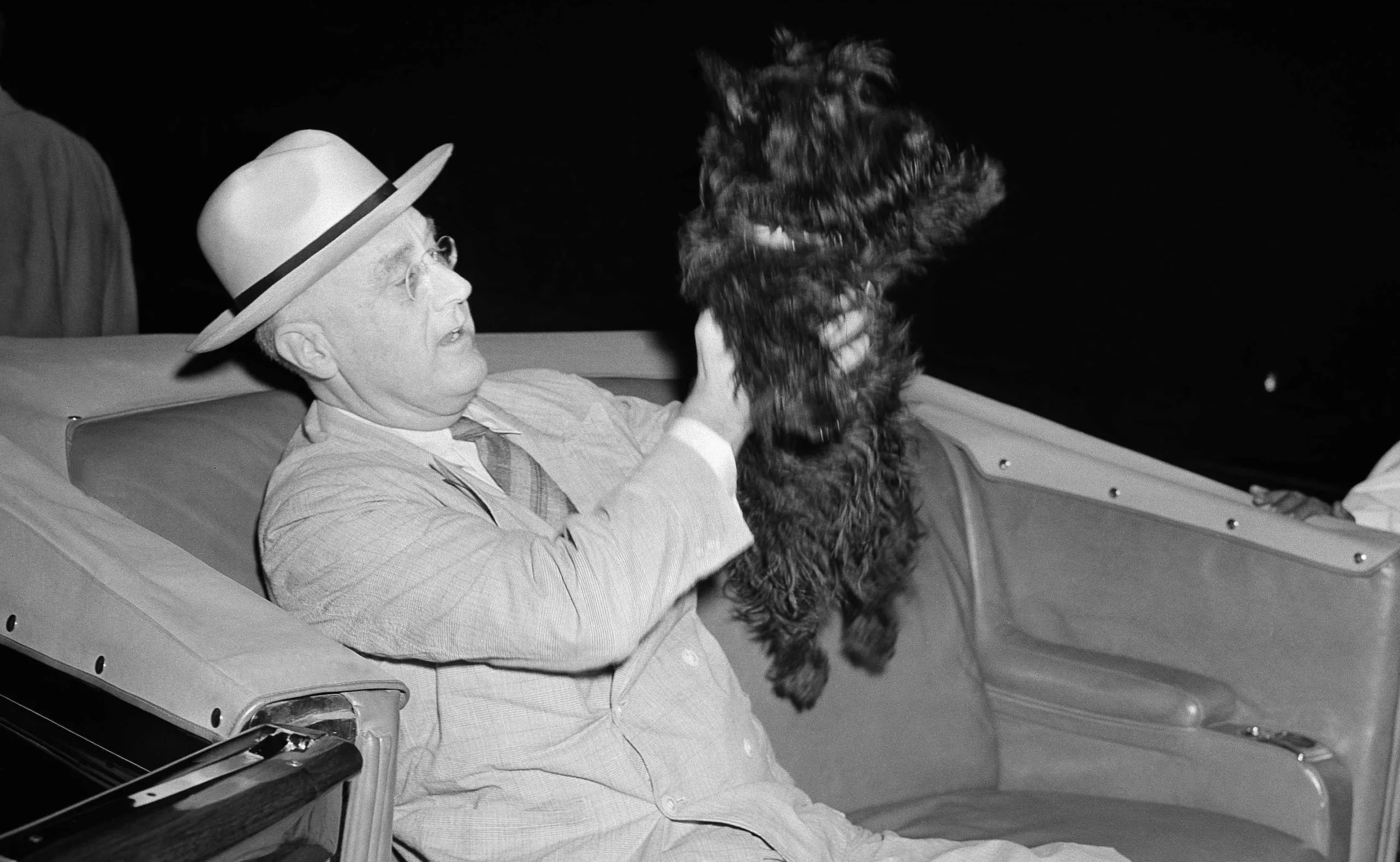 former president roosevelt holding his dog in a car