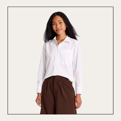 woman with dark hair wearing a white button up top and brown pants