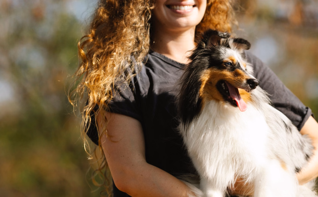 woman and small fluffy dog standing outside