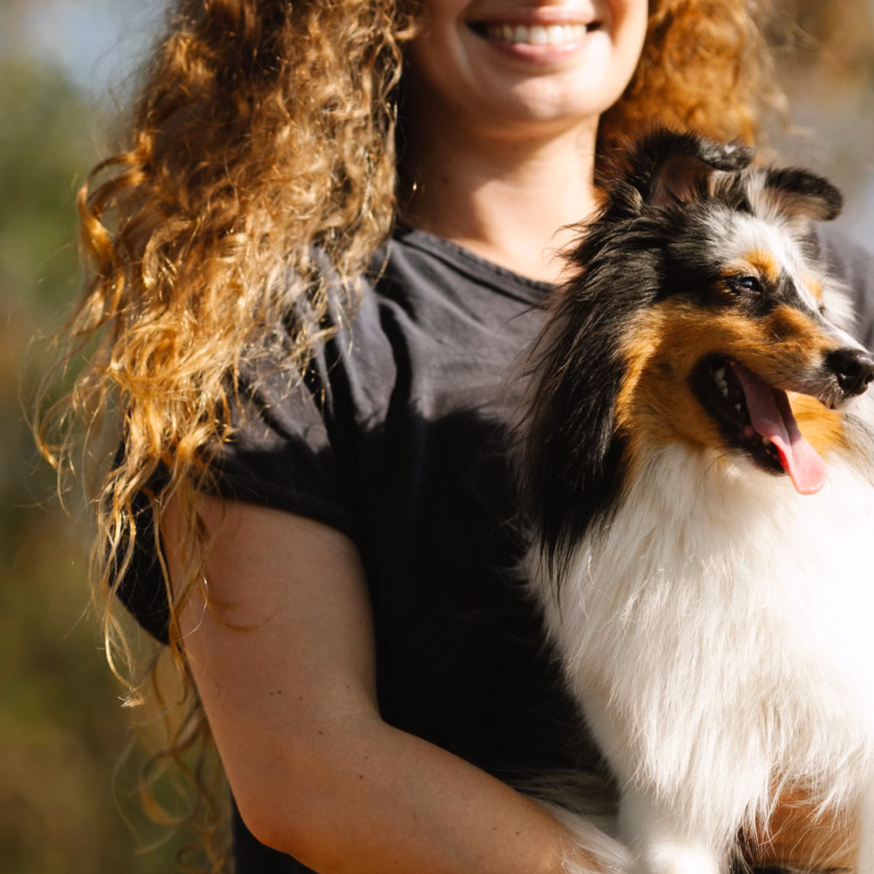 woman and small fluffy dog standing outside
